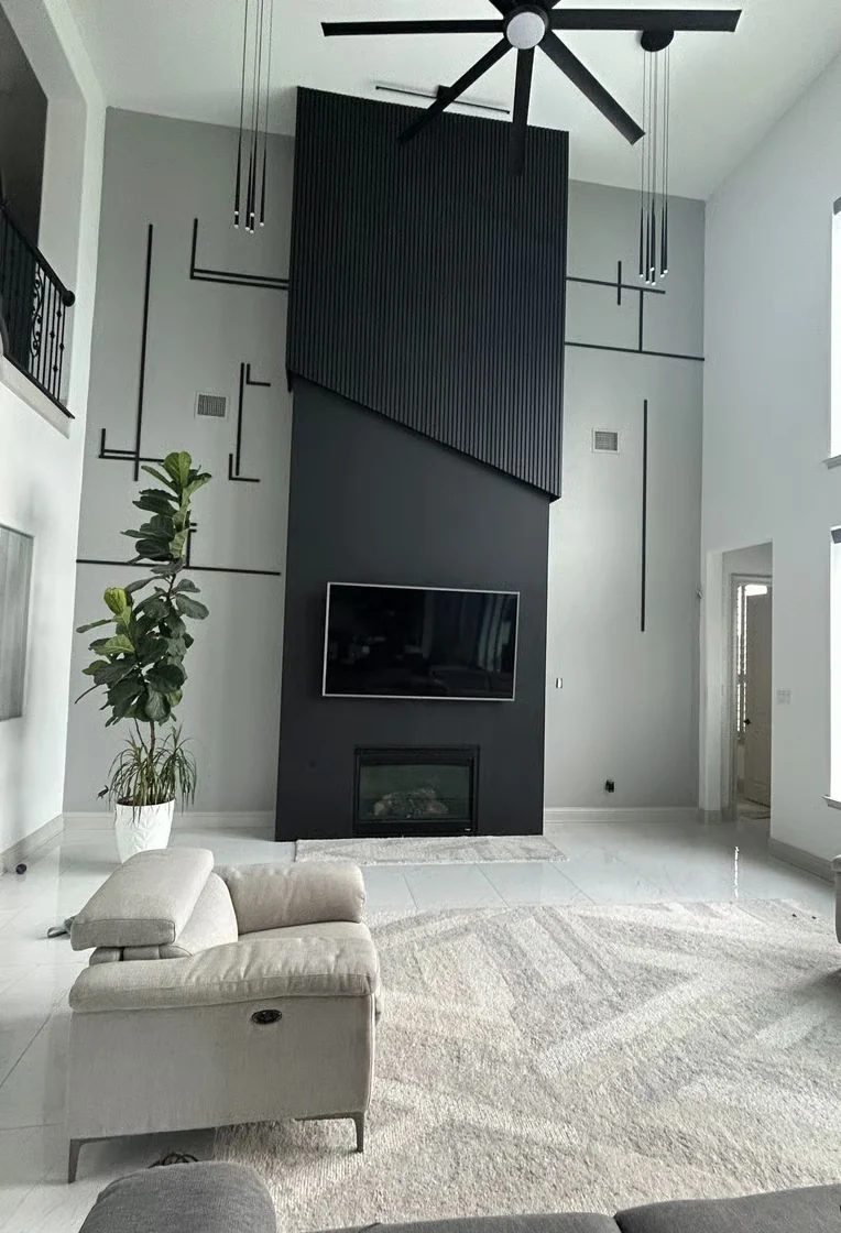 Finished living room with a dark modern fireplace wall